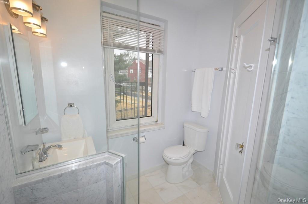 69 Harney Road, Unit 3A Scarsdale, NY 10583 - Photo 20 of 22 Fully renovated bath with marble tiled step-in shower.