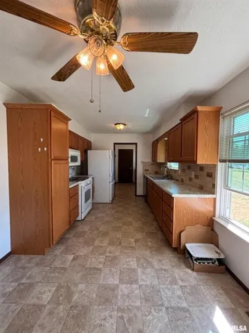 a room with stainless steel appliances kitchen island granite countertop a refrigerator and a stove top oven