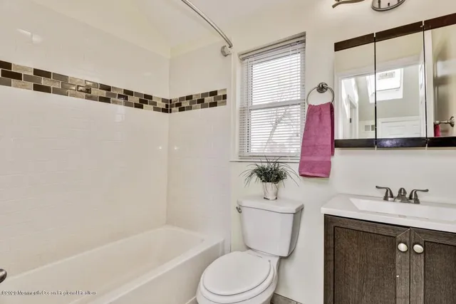a bathroom with a sink mirror toilet and bathtub