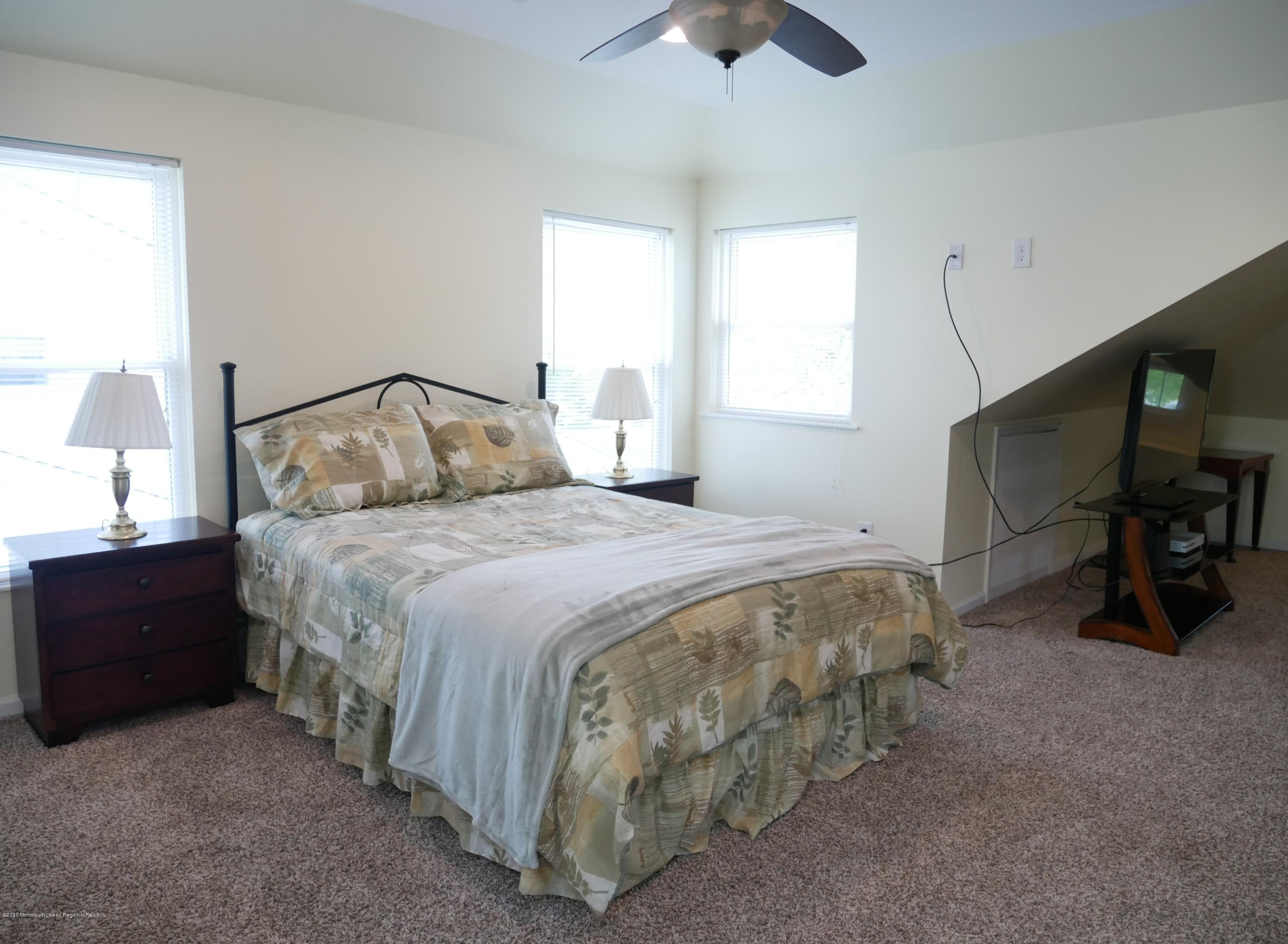 319 Arnold Avenue Point Pleasant Beach, NJ 08742 - Photo 25 of 34 a bedroom with a bed and a chandelier