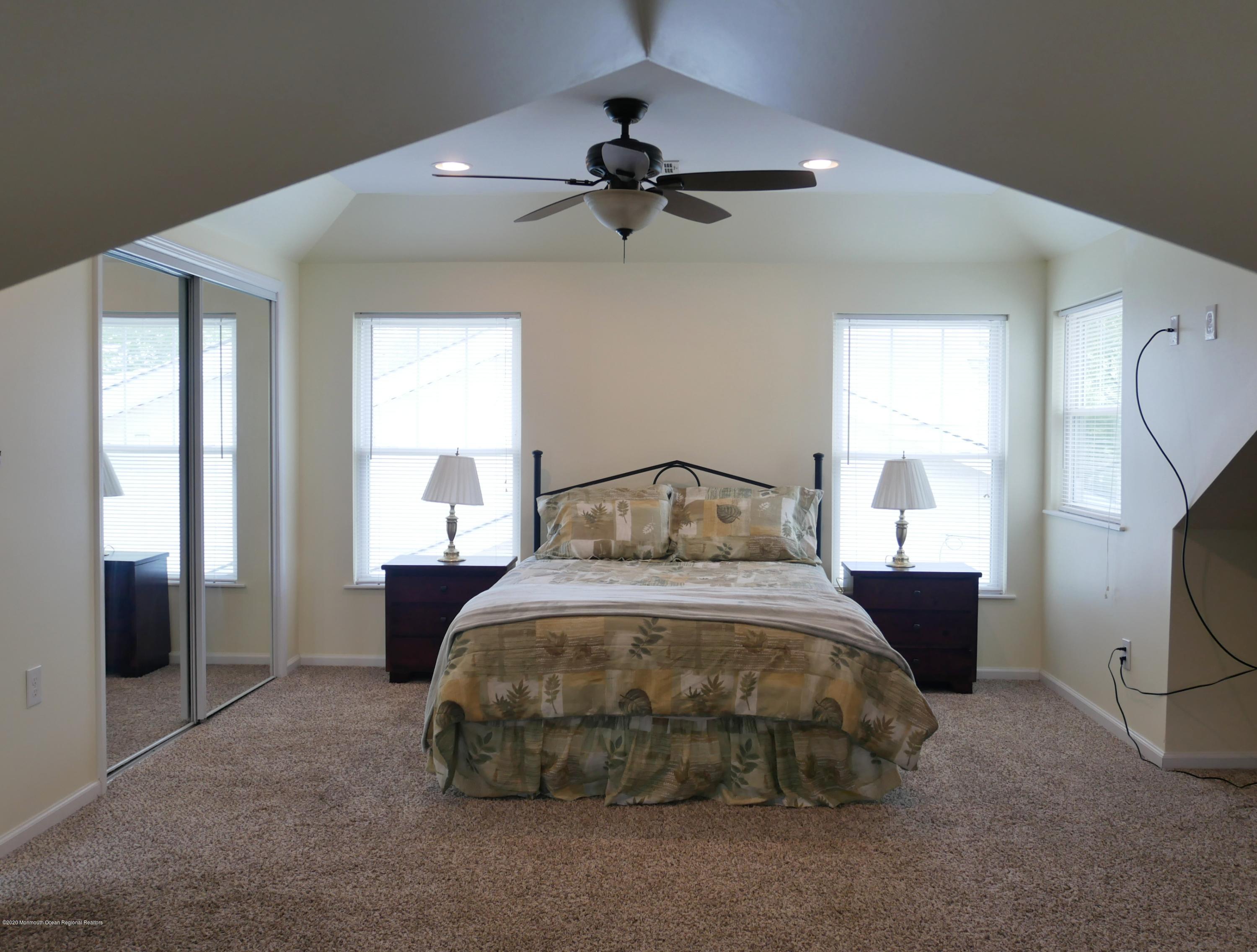 319 Arnold Avenue Point Pleasant Beach, NJ 08742 - Photo 26 of 34 a bedroom with a bed and a chandelier