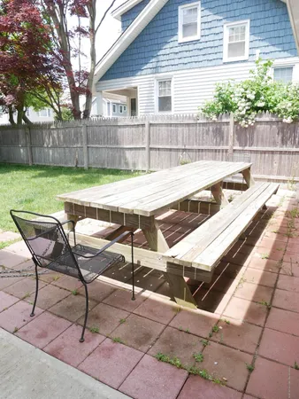 a view of a chairs and table in the backyard