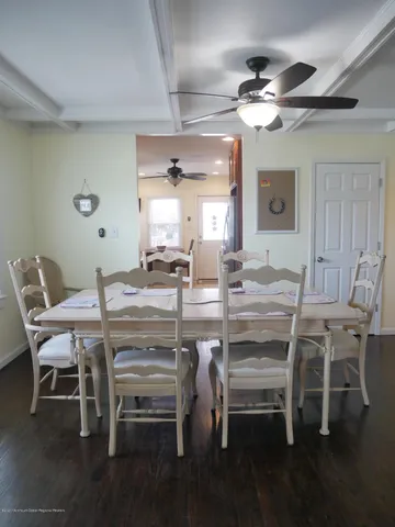 a dining room with wooden floor a chandelier a wooden table and chairs