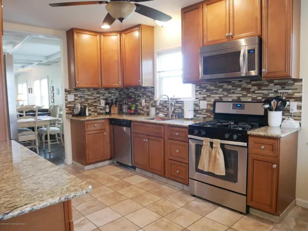 a kitchen with stainless steel appliances granite countertop a stove a sink and a microwave