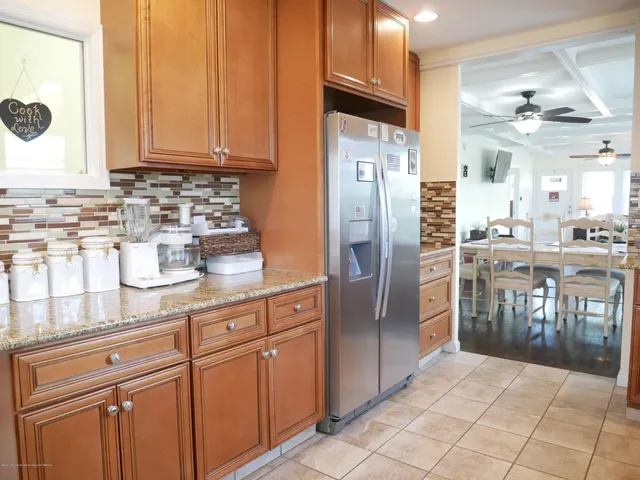 a kitchen with stainless steel appliances granite countertop a refrigerator and a stove top oven