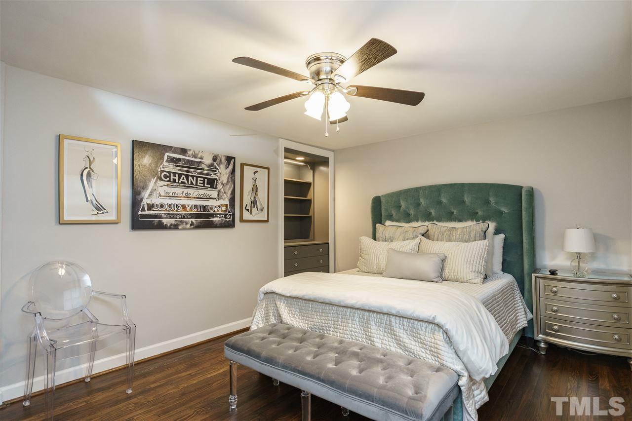 1641 Sutton Drive, Unit 3 Raleigh, NC 27605 - Photo 13 of 19 a bedroom with a large bed and a chandelier
