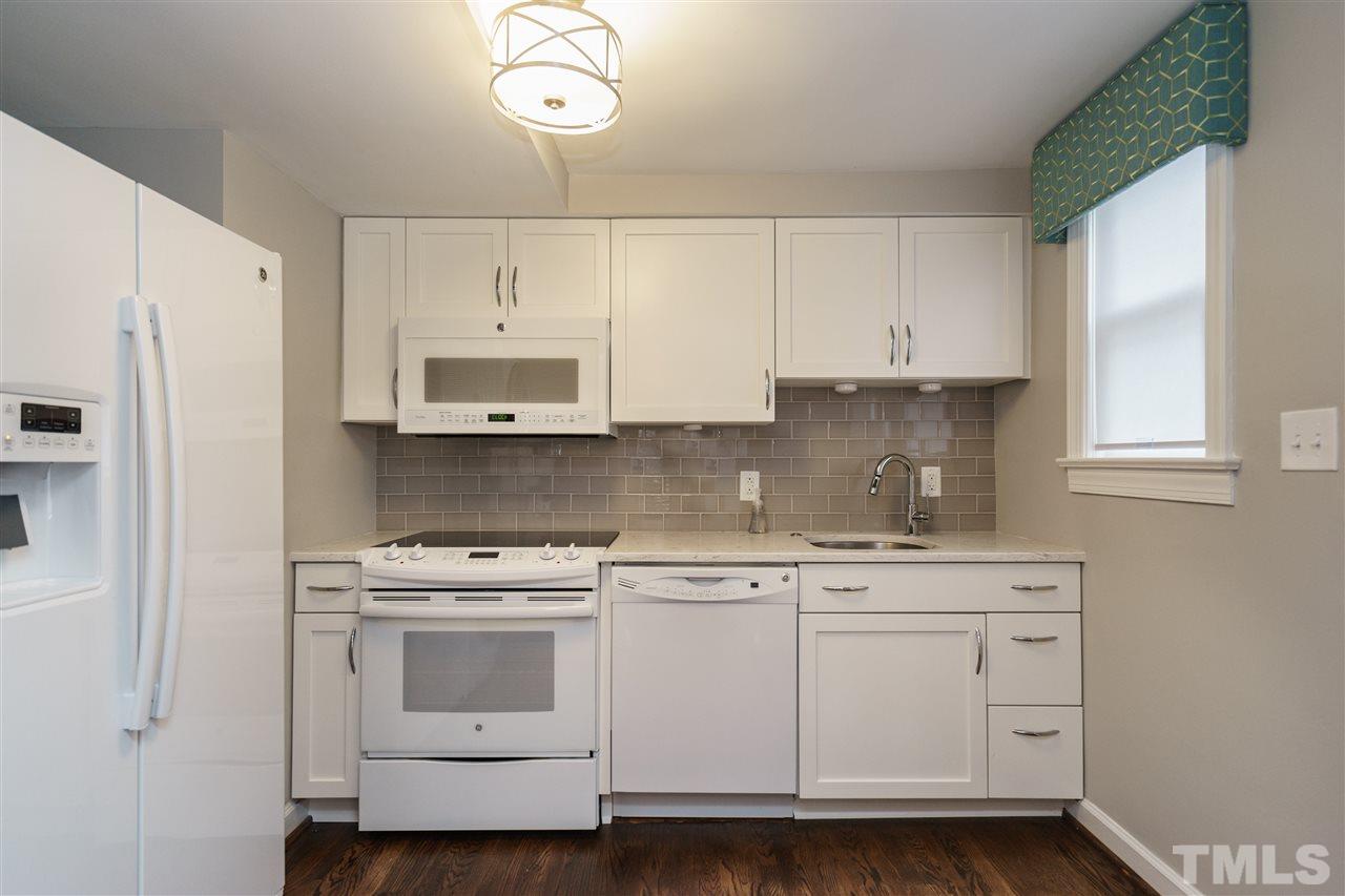 1641 Sutton Drive, Unit 3 Raleigh, NC 27605 - Photo 8 of 19 a kitchen with white cabinets and white appliances