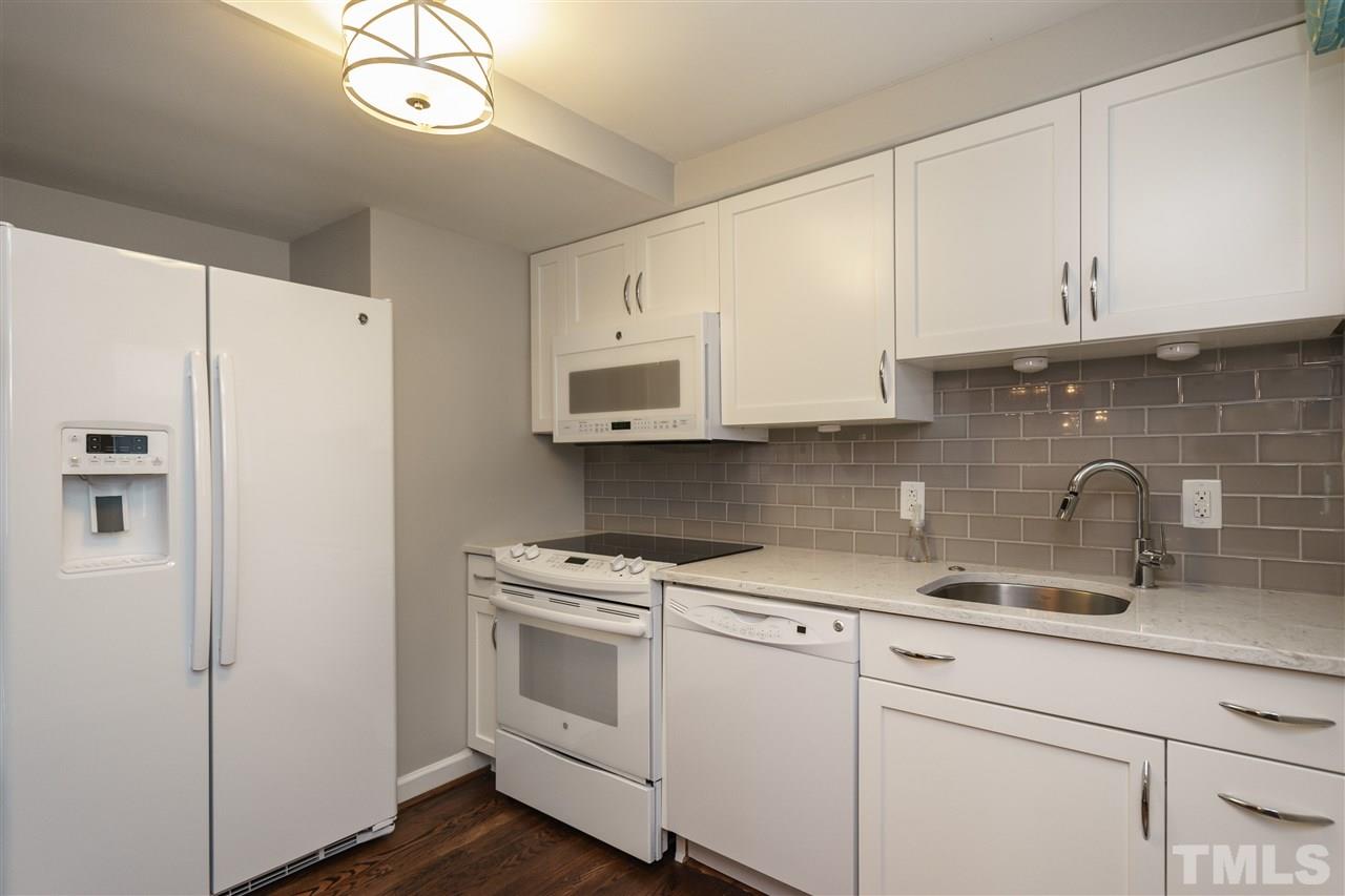 1641 Sutton Drive, Unit 3 Raleigh, NC 27605 - Photo 9 of 19 a kitchen with stainless steel appliances white cabinets and a refrigerator