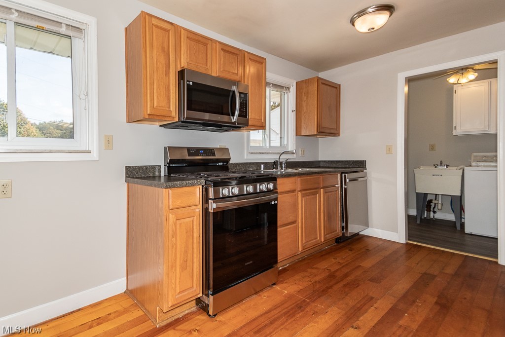 308 Wilson Mills Road Chardon, OH 44024 - Photo 8 of 21 Kitchen featuring stainless steel appliances, wood-type flooring, a wealth of natural light, and washer / dryer