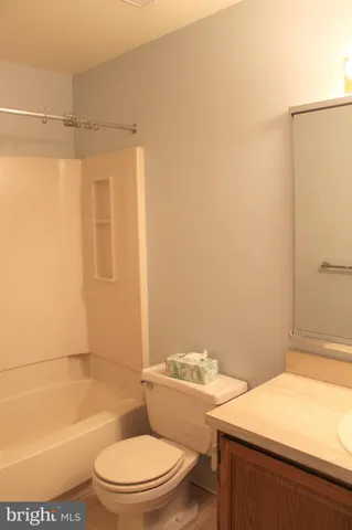 a white toilet and tub next to a bathroom sink