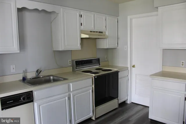 a kitchen with stainless steel appliances granite countertop a stove and a white cabinets