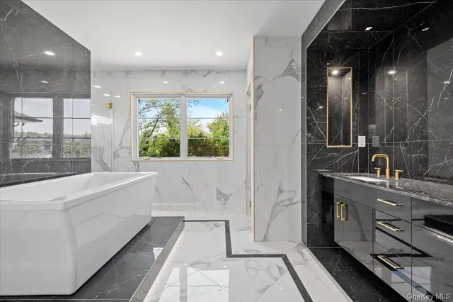 a bathroom with a double vanity sink a mirror and a bathtub