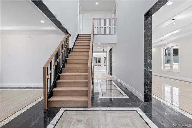 a view of staircase with lots of frames on wall and a window