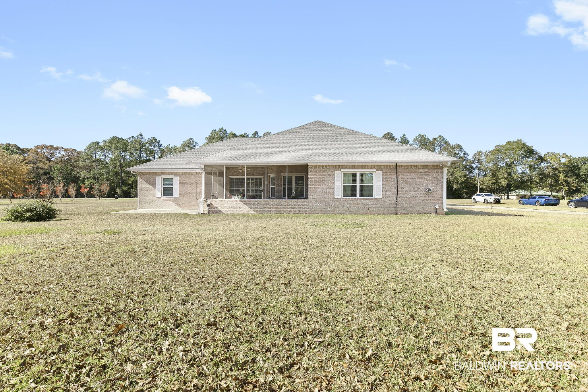 24130 Cowling Road Robertsdale, AL 36567 - Photo 48 of 71 Rear view of house featuring a sunroom and a lawn