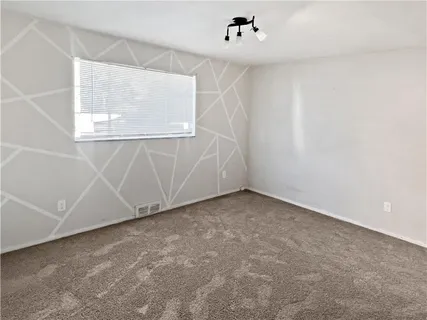 an empty room with a window and a ceiling fan