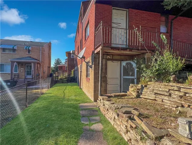 a view of a house with backyard and sitting area