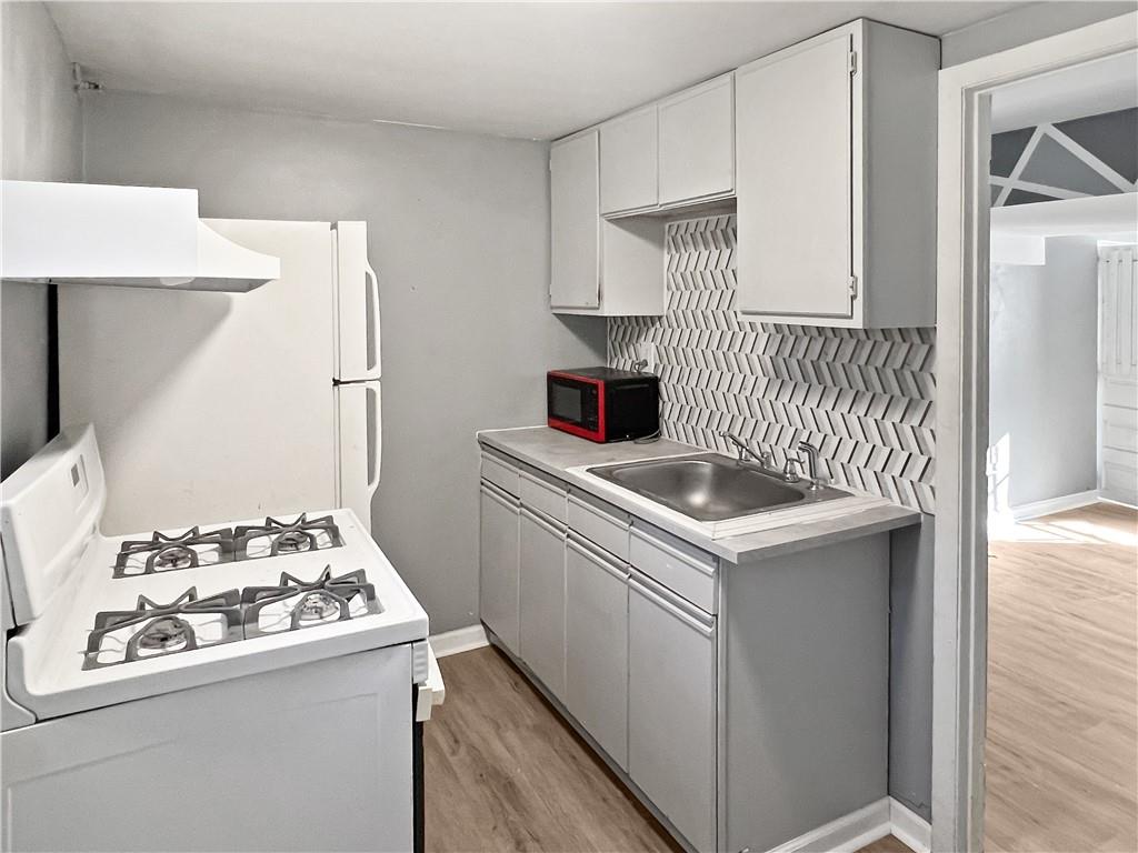 6444 Apple Street Pittsburgh, PA 15206 - Photo 22 of 28 a kitchen with a stove and a sink