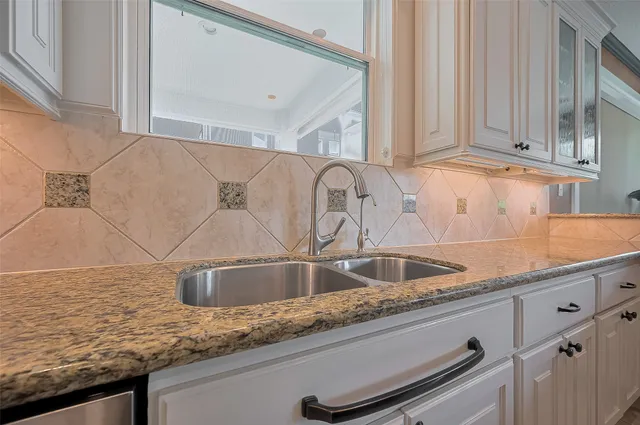 a kitchen with granite countertop a sink and cabinets