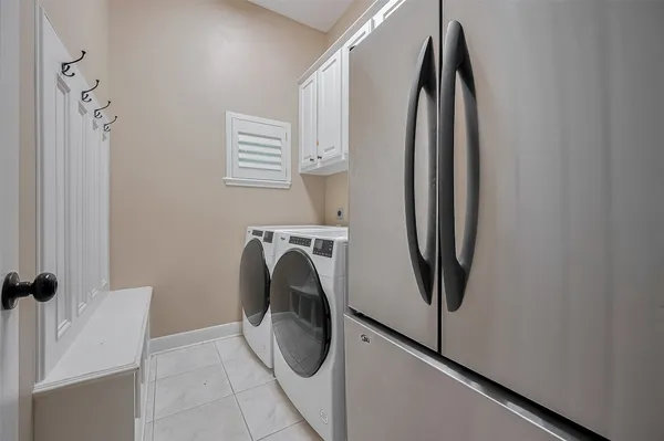 a view of walk in closet with clothes and washer