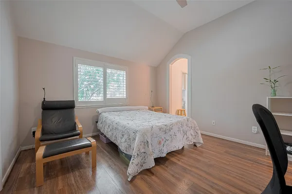 a bedroom with a bed and wooden floor