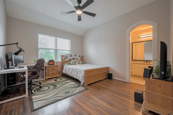 a bedroom with a bed and a flat tv screen on the dresser