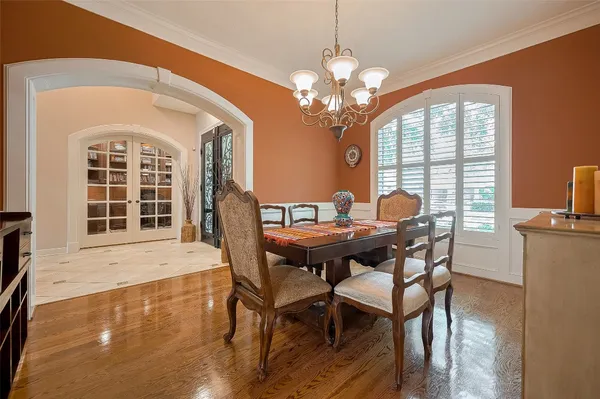 a view of a dining room with furniture a chandelier and wooden floor