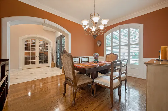 a view of a dining room with furniture a chandelier and wooden floor
