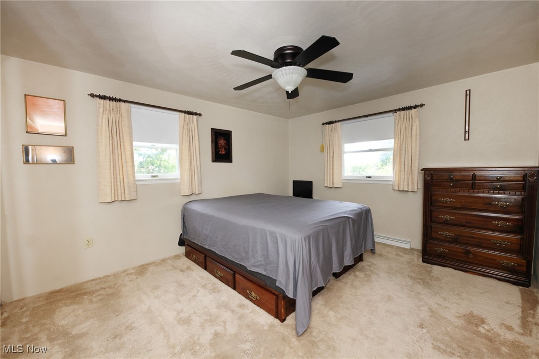 115 Carol Road Wellsburg, WV 26070 - Photo 22 of 36 Bedroom with multiple windows, light carpet, a ceiling fan, and a baseboard radiator