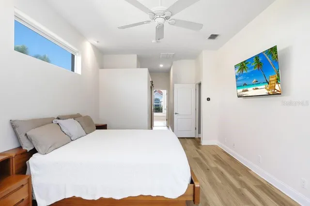 a spacious bedroom with a bed and a painting on the wall