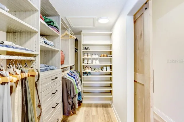 a view of walk in closet with clothes and shoes
