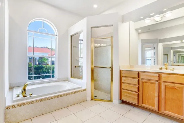 a spacious bathroom with a tub sink and mirror