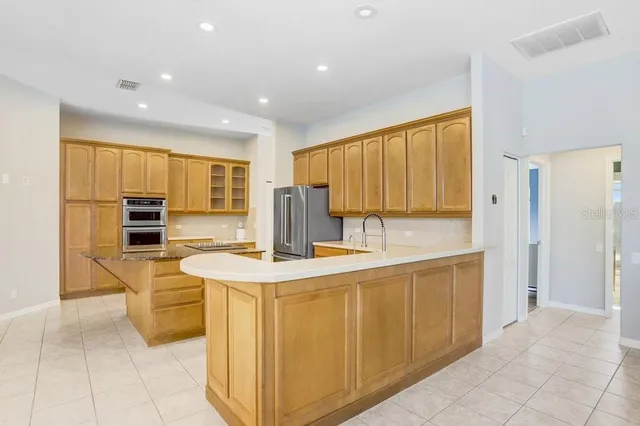 a kitchen with stainless steel appliances granite countertop a sink and a refrigerator