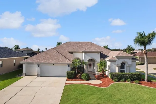 a front view of a house with a yard and potted plants