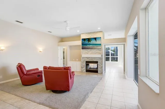 a living room with furniture a fireplace and a large window