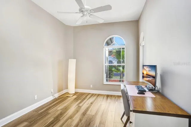 a view of a room with window ceiling fan and wooden floor