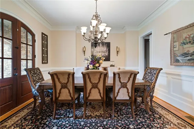 a view of a dining room with furniture a chandelier and wooden floor