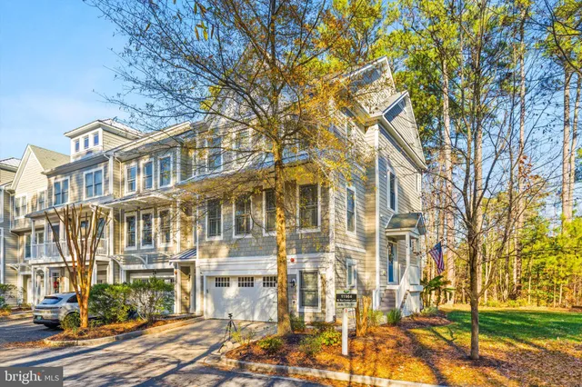 a kitchen with stainless steel appliances a sink a stove a refrigerator and white cabinets with wooden floor