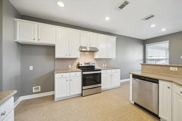 a kitchen with granite countertop white cabinets and white appliances