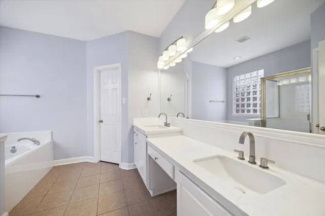 a bathroom with a sink a vanity a mirror and a bathtub