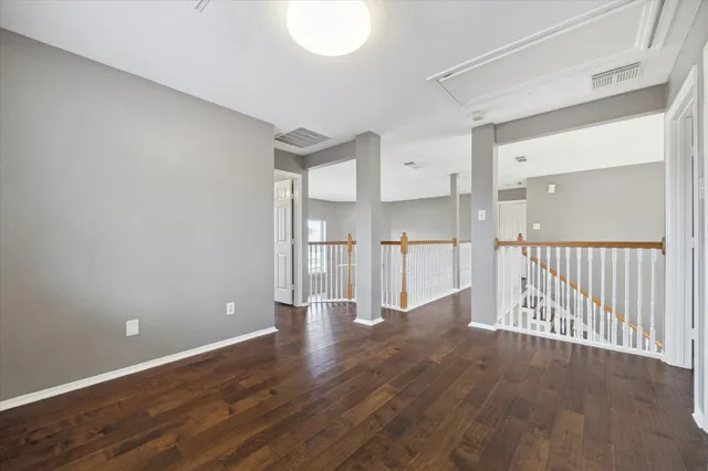a view of empty room with wooden floor