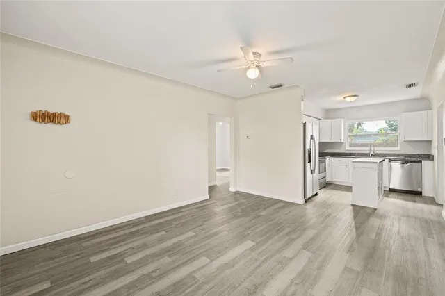 a view of kitchen with wooden floor electronic appliances and window