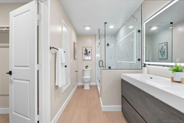 a spacious bathroom with a sink a large mirror and shower