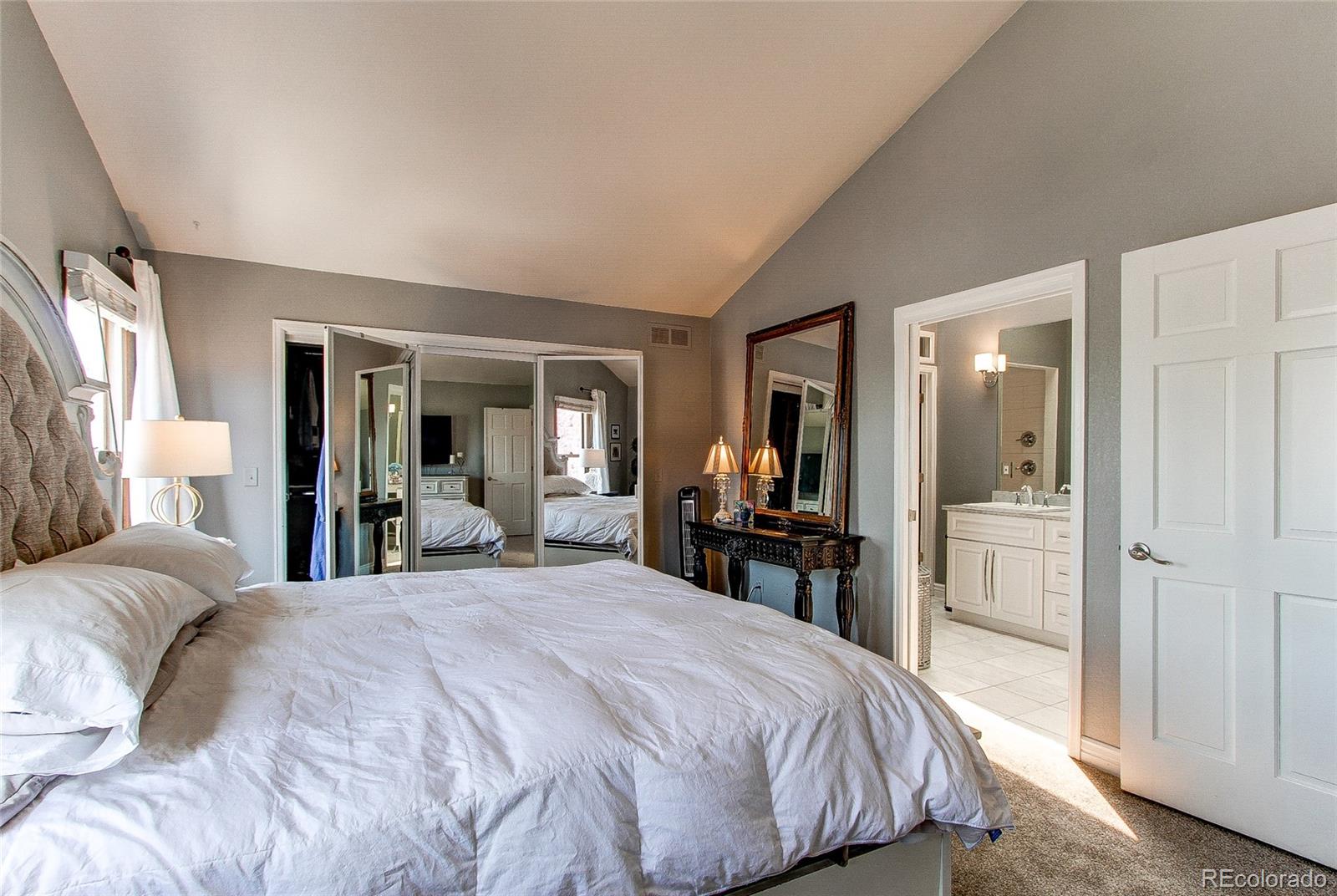 8028 Chaparral Road Lone Tree, CO 80124 - Photo 22 of 40 a large bedroom with a bed and large mirror with window