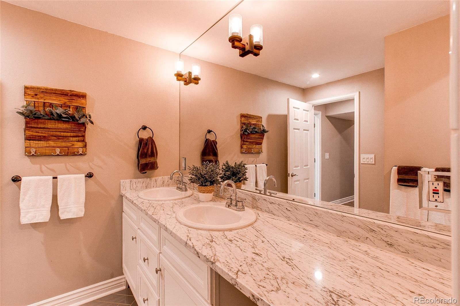 8028 Chaparral Road Lone Tree, CO 80124 - Photo 32 of 40 a bathroom with a sink double vanity granite and a mirror