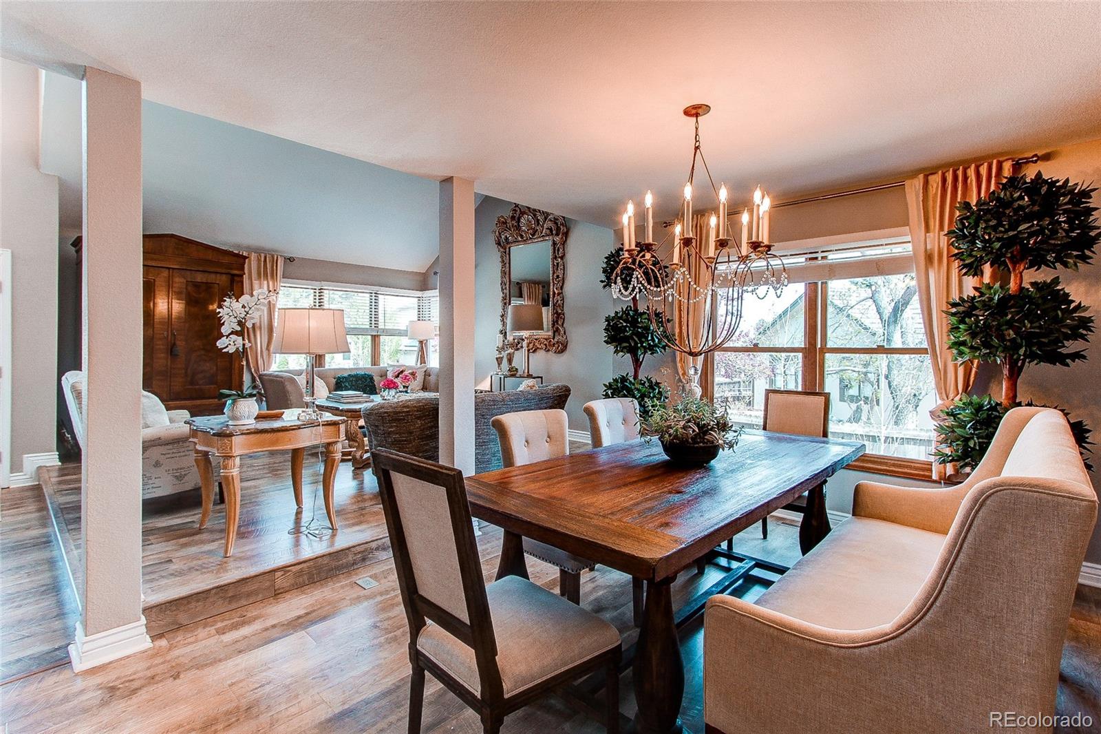 8028 Chaparral Road Lone Tree, CO 80124 - Photo 9 of 40 a dining room with wooden floor a chandelier a wooden table and chairs