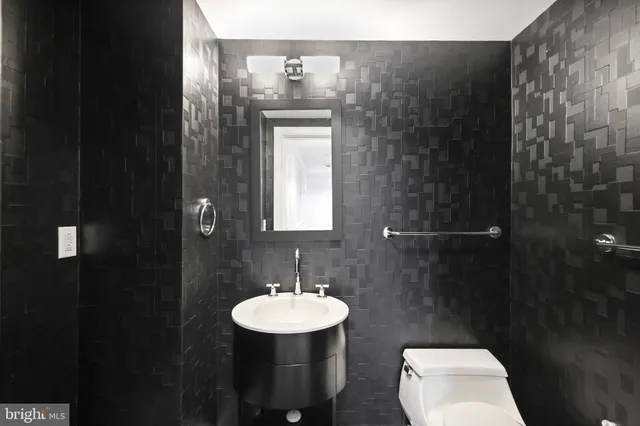 a bathroom with a granite countertop sink a toilet and a mirror