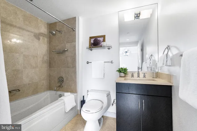 a kitchen with stainless steel appliances a refrigerator a sink dishwasher a stove and white cabinets with wooden floor