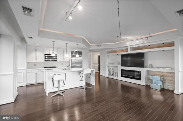 a large kitchen with cabinets wooden floor and stainless steel appliances