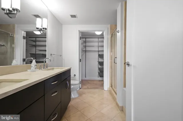 a bathroom with a granite countertop toilet a sink and a mirror