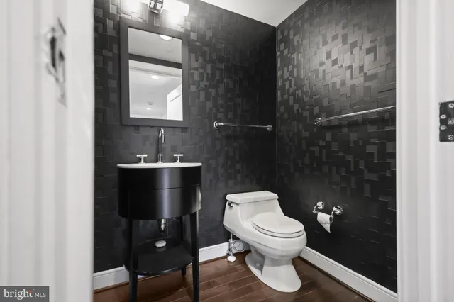 a bathroom with a granite countertop toilet a sink and a mirror